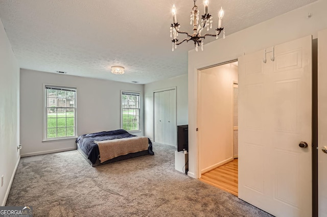 1739 Brandy Woods Trl SE, Conyers, GA 30013 - bedroom with light colored carpet, a textured ceiling, a chandelier, and baseboards