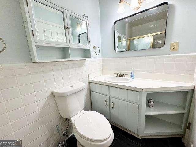 198 Swift Creek Rd, Cordele, GA 31015 - bathroom with tile walls, vanity, tile patterned floors, toilet, and wainscoting