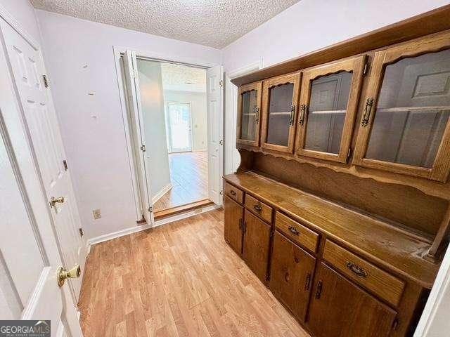198 Swift Creek Rd, Cordele, GA 31015 - doorway to outside featuring light wood-style flooring, a textured ceiling, and baseboards