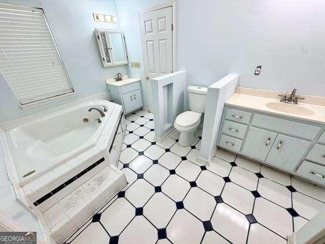 198 Swift Creek Rd, Cordele, GA 31015 - bathroom with vanity, a jetted tub, toilet, and tile patterned floors