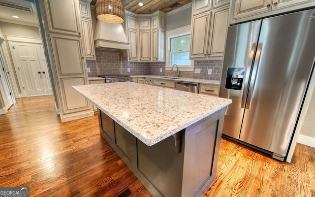 2628 Rolling River Dr, Hiawassee, GA 30546 - kitchen with appliances with stainless steel finishes, wall chimney exhaust hood, a sink, light wood-type flooring, and light stone countertops