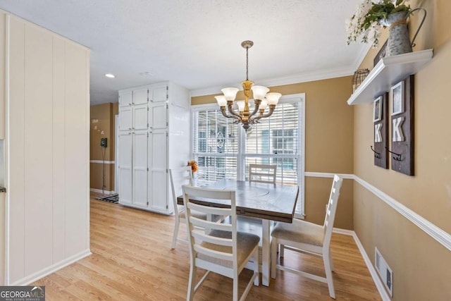 2019 Wiltshire Pl, Snellville, GA 30078 - dining space with light wood-style flooring, a chandelier, and ornamental molding
