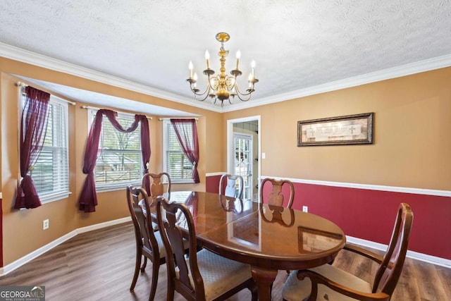 2019 Wiltshire Pl, Snellville, GA 30078 - dining room with wood finished floors, a chandelier, a textured ceiling, and ornamental molding