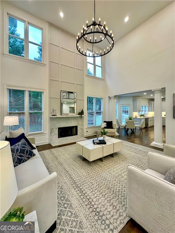 365 Morning Dew Cir, Roswell, GA 30075 - living room with a towering ceiling, decorative columns, plenty of natural light, a chandelier, and wood finished floors