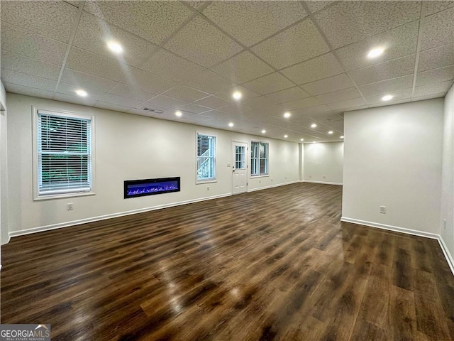 365 Morning Dew Cir, Roswell, GA 30075 - unfurnished room with dark wood-type flooring, baseboards, a glass covered fireplace, a paneled ceiling, and recessed lighting
