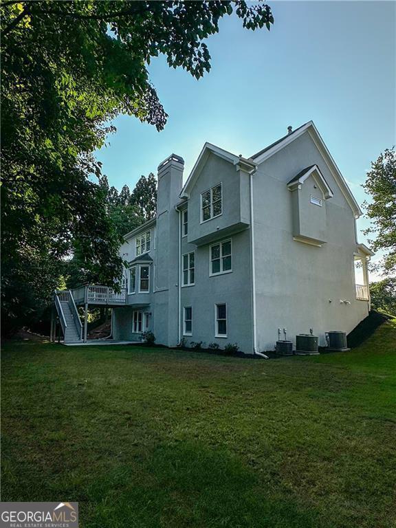 365 Morning Dew Cir, Roswell, GA 30075 - back of house with stucco siding, a lawn, a chimney, central AC, and stairs