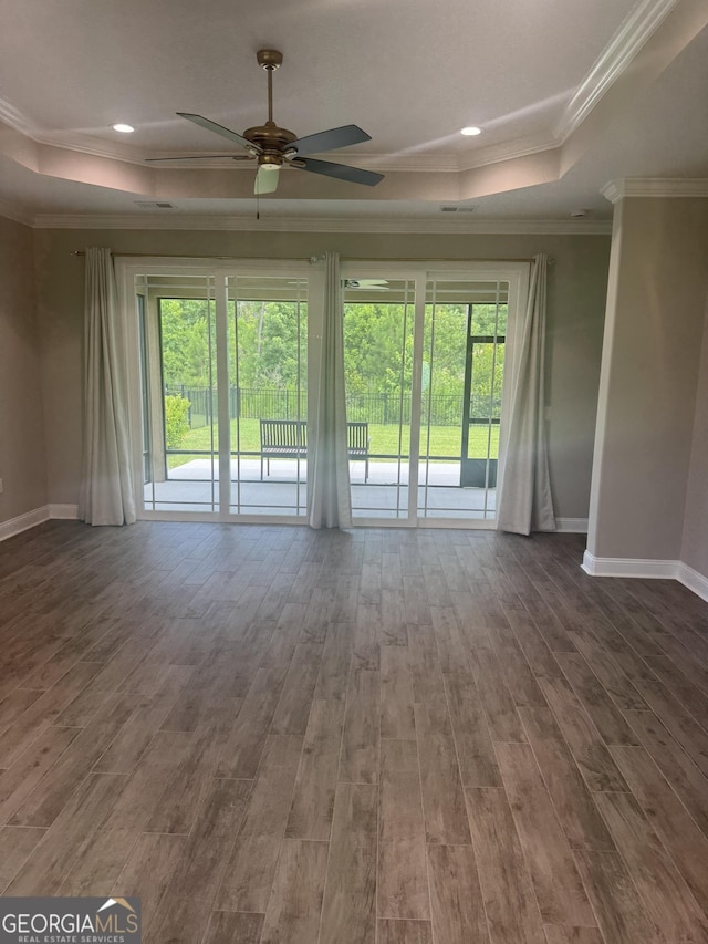 223 Ryan Nicholas Dr, Kingsland, GA 31548 - unfurnished living room featuring a raised ceiling, healthy amount of natural light, ceiling fan, baseboards, and crown molding