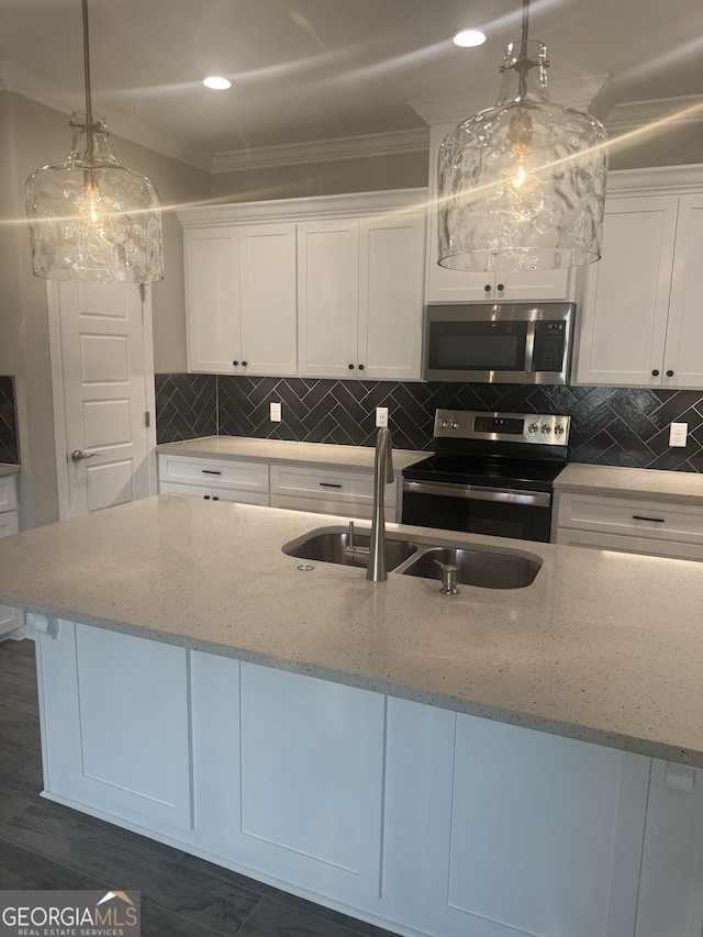 223 Ryan Nicholas Dr, Kingsland, GA 31548 - kitchen featuring stainless steel appliances, white cabinets, a sink, crown molding, and backsplash