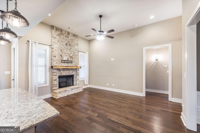 213 Barnyard Way, Perry, GA 31069 - unfurnished living room with dark wood-style flooring, a ceiling fan, baseboards, a stone fireplace, and recessed lighting