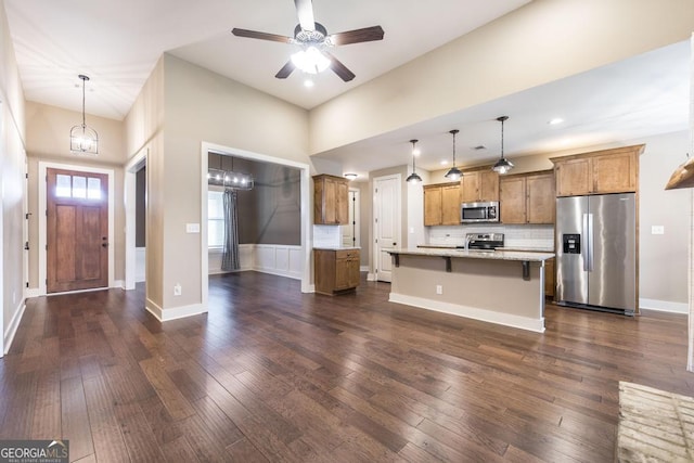 213 Barnyard Way, Perry, GA 31069 - kitchen featuring stainless steel appliances, brown cabinets, dark wood-style floors, a kitchen breakfast bar, and recessed lighting