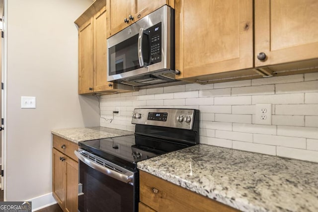 213 Barnyard Way, Perry, GA 31069 - kitchen with stainless steel appliances, backsplash, and light stone counters