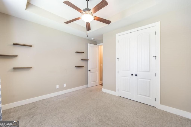 213 Barnyard Way, Perry, GA 31069 - unfurnished bedroom with carpet floors, a closet, baseboards, a ceiling fan, and a raised ceiling
