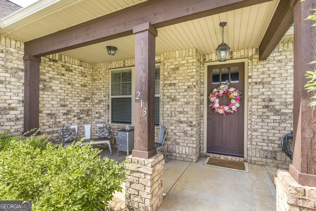 213 Barnyard Way, Perry, GA 31069 - property entrance with a porch and brick siding