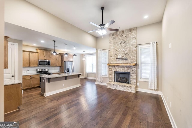 213 Barnyard Way, Perry, GA 31069 - kitchen with appliances with stainless steel finishes, open floor plan, brown cabinets, dark wood-style flooring, and recessed lighting