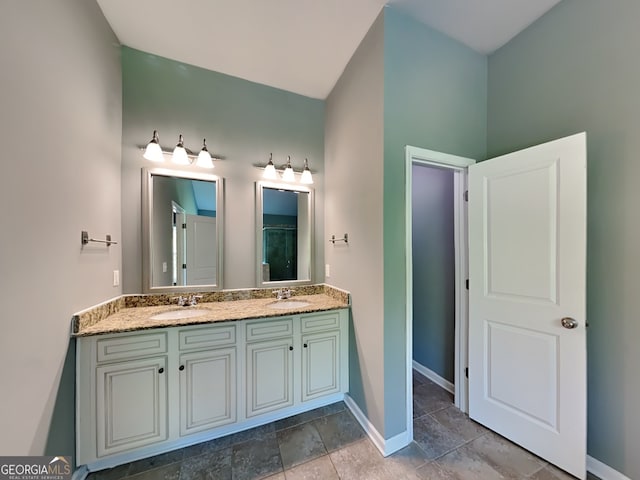 3507 Hideaway Ln, Loganville, GA 30052 - bathroom featuring double vanity, baseboards, and stone finish floors