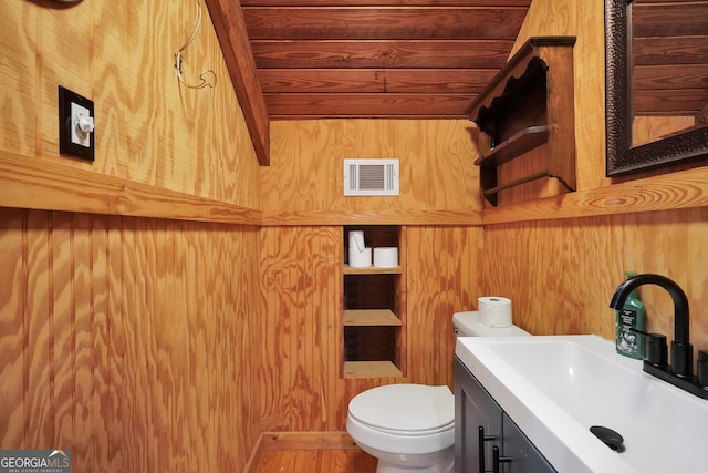 121 Samples Rd, Forsyth, GA 31029 - half bathroom featuring toilet, vanity, and wooden walls