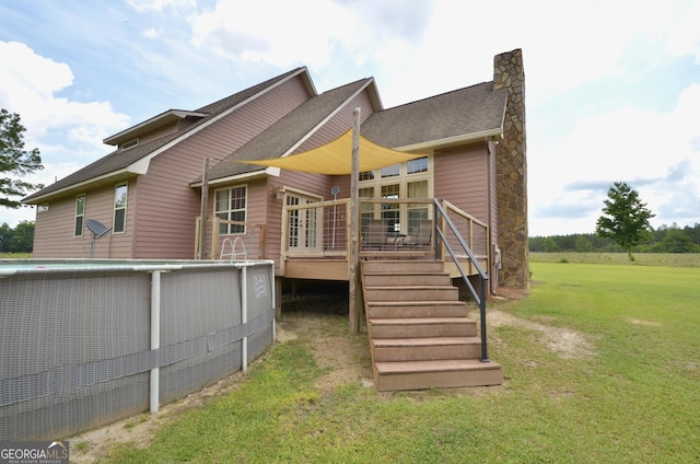 2025 Chicken Rd, Dudley, GA 31022 - back of property with a wooden deck, a yard, a chimney, roof with shingles, and stone siding