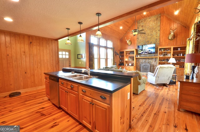 2025 Chicken Rd, Dudley, GA 31022 - kitchen featuring dishwasher, dark countertops, wood walls, light wood-type flooring, and a kitchen island with sink