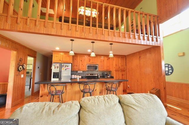 2025 Chicken Rd, Dudley, GA 31022 - kitchen with appliances with stainless steel finishes, wooden walls, light wood finished floors, open floor plan, and dark countertops