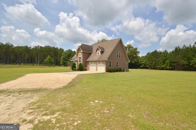2025 Chicken Rd, Dudley, GA 31022 - view of home's exterior with a garage, concrete driveway, a wooded view, and a lawn