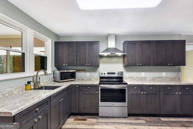 1069 Shellman Hammock Dr NE, Townsend, GA 31331 - kitchen with wall chimney exhaust hood, appliances with stainless steel finishes, a sink, light wood-type flooring, and light countertops