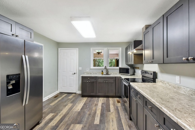 1069 Shellman Hammock Dr NE, Townsend, GA 31331 - kitchen with stainless steel appliances, a sink, dark wood finished floors, wall chimney range hood, and baseboards