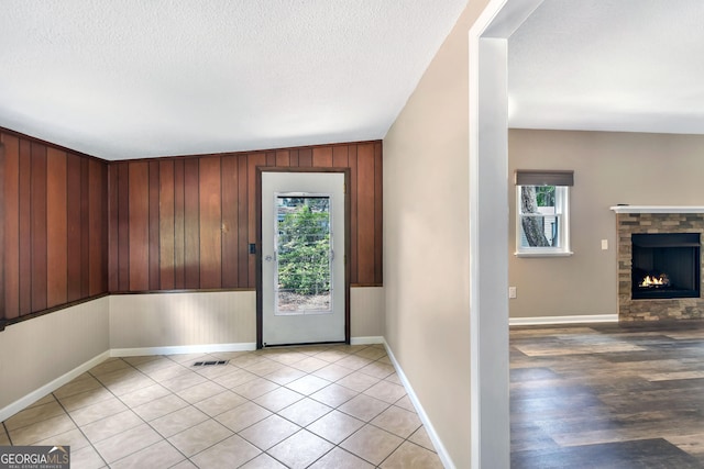 1069 Shellman Hammock Dr NE, Townsend, GA 31331 - entrance foyer featuring healthy amount of natural light, wood walls, a textured ceiling, a fireplace, and baseboards