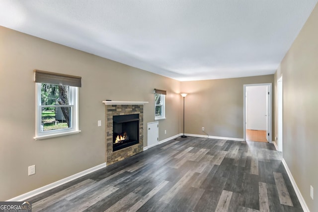 1069 Shellman Hammock Dr NE, Townsend, GA 31331 - unfurnished living room with plenty of natural light, a fireplace, dark wood-type flooring, and baseboards