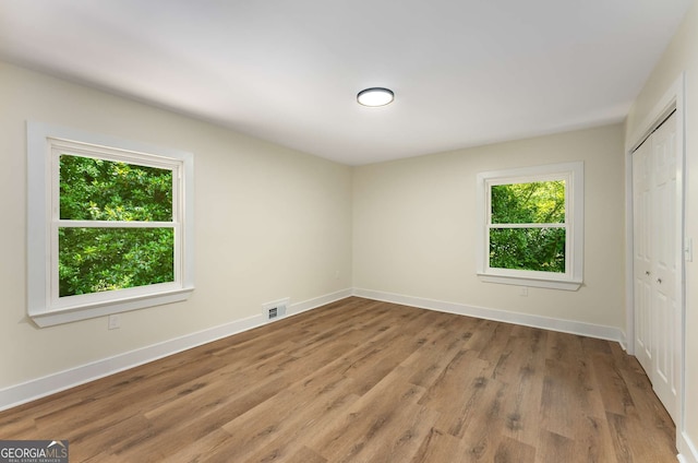 1364 Willis Mill Rd SW, Atlanta, GA 30311 - unfurnished bedroom featuring multiple windows, a closet, wood finished floors, and baseboards