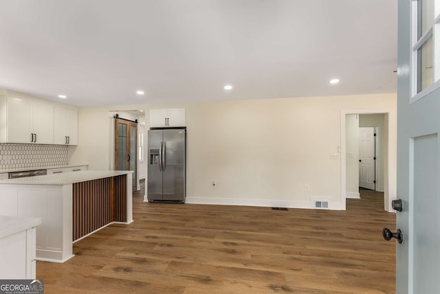 1364 Willis Mill Rd SW, Atlanta, GA 30311 - kitchen with appliances with stainless steel finishes, a barn door, white cabinetry, wood finished floors, and recessed lighting