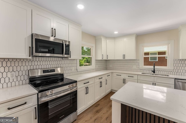 1364 Willis Mill Rd SW, Atlanta, GA 30311 - kitchen featuring stainless steel appliances, a sink, light stone counters, light wood-style floors, and tasteful backsplash