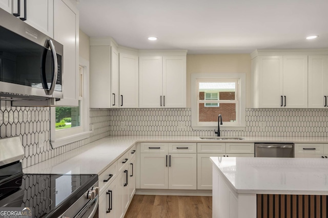 1364 Willis Mill Rd SW, Atlanta, GA 30311 - kitchen featuring stainless steel appliances, a sink, light wood finished floors, recessed lighting, and white cabinets