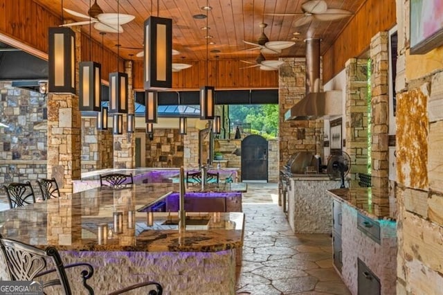 37 Retreat Rdg, Cartersville, GA 30120 - kitchen with wood ceiling, ceiling fan, stone floors, wall chimney range hood, and wood walls