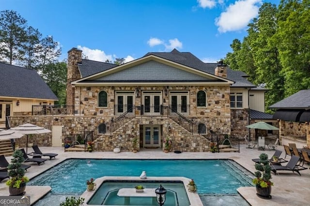 37 Retreat Rdg, Cartersville, GA 30120 - back of property featuring french doors, a chimney, stone siding, stairs, and a pool with connected hot tub