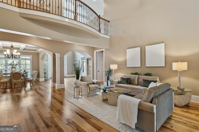 37 Retreat Rdg, Cartersville, GA 30120 - living room featuring arched walkways, a chandelier, wood finished floors, and ornate columns