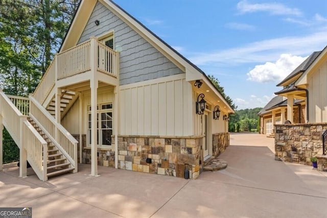 37 Retreat Rdg, Cartersville, GA 30120 - view of home's exterior with stairs, a balcony, stone siding, and board and batten siding