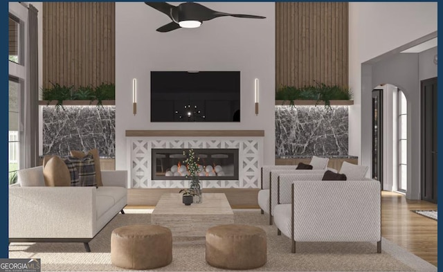 0 Ebenezer Rd Unit 4, Fayetteville, GA 30215 - living room featuring arched walkways, wood finished floors, a ceiling fan, and a glass covered fireplace