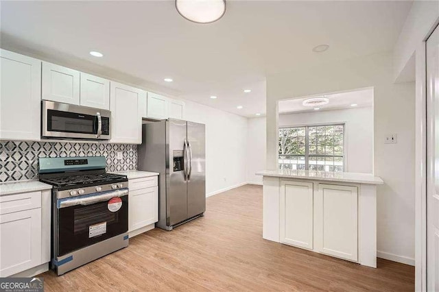 4201 Regal Ridge Rd, Austell, GA 30106 - kitchen featuring stainless steel appliances, light countertops, decorative backsplash, light wood finished floors, and white cabinetry