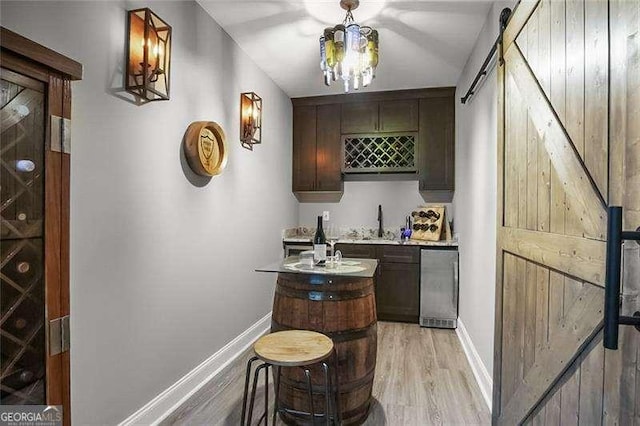 715 Creekside Bnd, Alpharetta, GA 30004 - indoor wet bar with a barn door, baseboards, and light wood finished floors