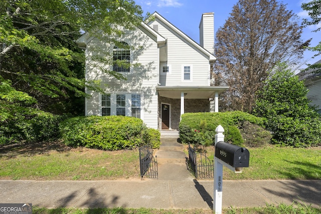 1995 Liberty Hts, Fairburn, GA 30213 - traditional home with a gate, a fenced front yard, a chimney, stone siding, and covered porch