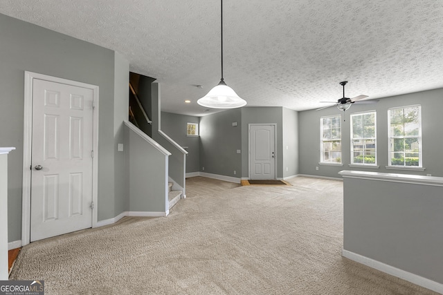 1995 Liberty Hts, Fairburn, GA 30213 - unfurnished living room with carpet floors, a ceiling fan, baseboards, stairs, and a textured ceiling