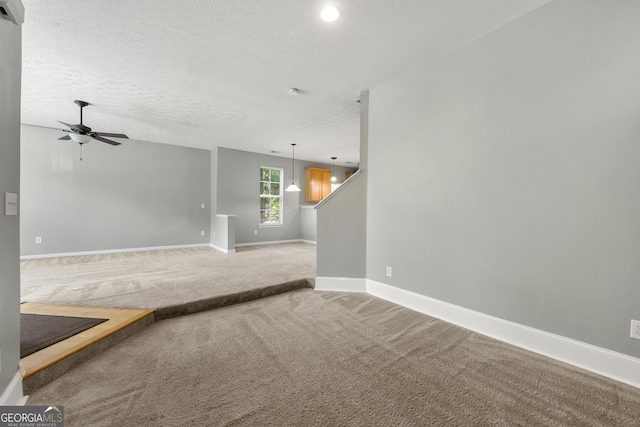 1995 Liberty Hts, Fairburn, GA 30213 - unfurnished living room with a textured ceiling, carpet flooring, baseboards, and a ceiling fan
