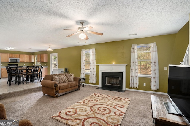 3740 Arminto Dr, Ellenwood, GA 30294 - living room with light carpet, ceiling fan, a fireplace with flush hearth, a textured ceiling, and baseboards