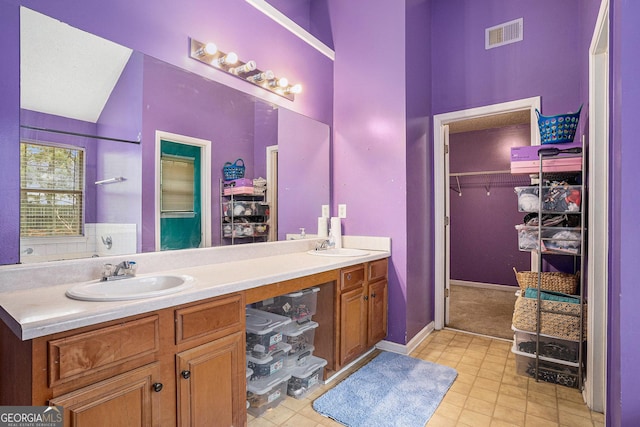 3740 Arminto Dr, Ellenwood, GA 30294 - full bath featuring double vanity, a walk in closet, and tile patterned floors