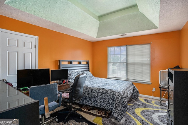 3740 Arminto Dr, Ellenwood, GA 30294 - carpeted bedroom with a desk, a textured ceiling, baseboards, and a raised ceiling