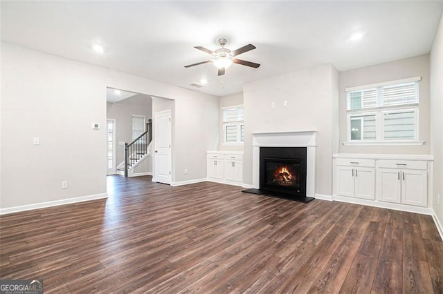3514 Ambassador Aly, Scottdale, GA 30079 - unfurnished living room featuring a ceiling fan, dark wood-style floors, a glass covered fireplace, and baseboards
