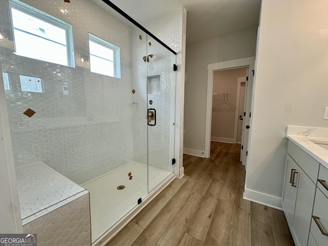 7040 Manchester Dr, Flowery Branch, GA 30542 - full bathroom featuring vanity, wood finished floors, a stall shower, and a spacious closet