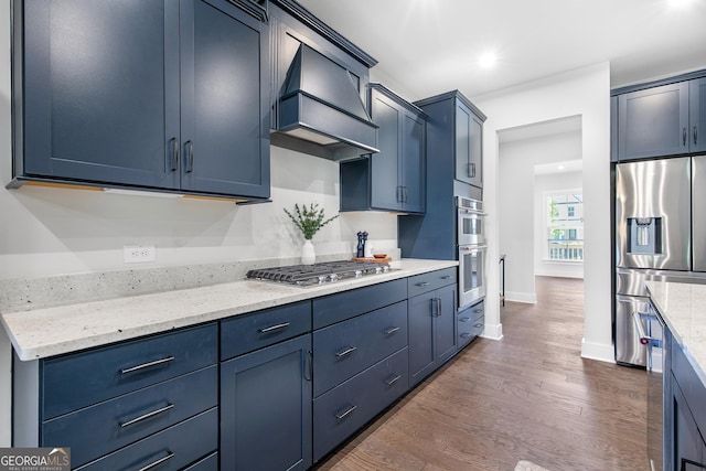 411 Riverclub Rd, Acworth, GA 30101 - kitchen with appliances with stainless steel finishes, premium range hood, dark wood finished floors, blue cabinetry, and light stone countertops