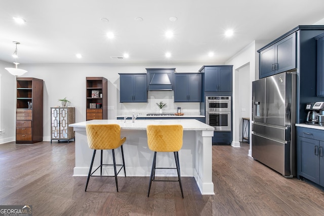 411 Riverclub Rd, Acworth, GA 30101 - kitchen featuring appliances with stainless steel finishes, custom range hood, a breakfast bar area, a kitchen island with sink, and dark wood-style flooring