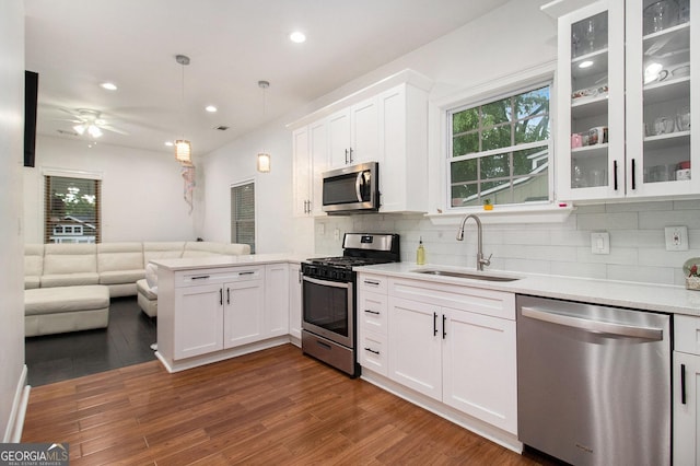 1292 Eubanks Ave, East Point, GA 30344 - kitchen featuring appliances with stainless steel finishes, open floor plan, a peninsula, decorative backsplash, and recessed lighting